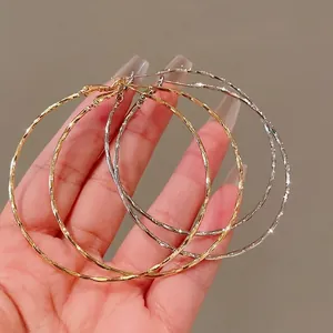 Stylish large twisted metal hoop earrings set in gold and silver tones for women