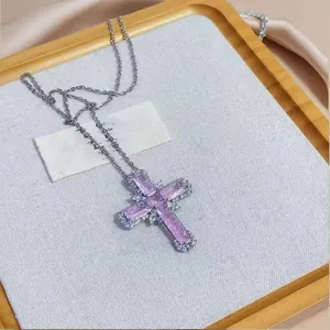 Close-up of elegant purple zircon cross pendant necklace on a jewelry display tray