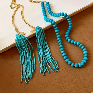 Vue détaillée d'un collier bohème en perles turquoise avec pompons et breloques de feuilles