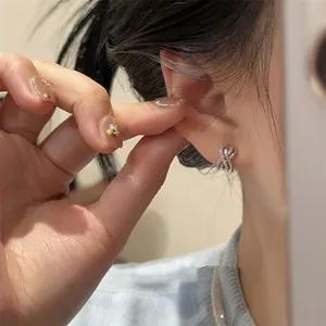Elegant silver crossed circular hollow earrings with sparkling cubic zirconia on model's ear
