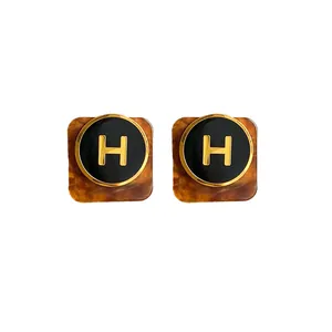 Orecchini a perno vintage geometrici con logo H dorato e trama tartarugata marrone