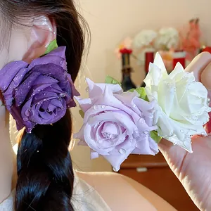 Vista dettagliata di orecchini a rosa in tessuto in viola, lavanda e bianco