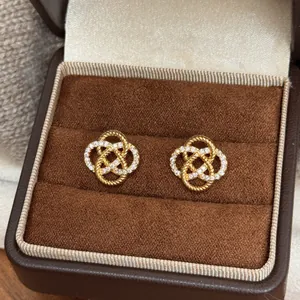 Elegant gold hollow knot flower stud earrings with sparkling CZ stones in a gift box
