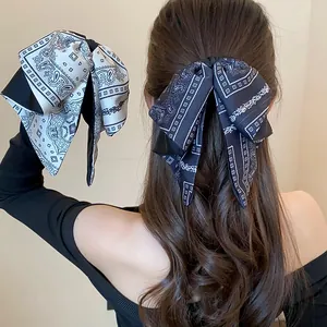 Detailed close-up showing a vintage paisley bow hair clip styled on a model's half-up hairstyle