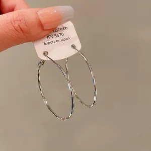 Close-up of silver-tone textured hoop earrings with a hammered finish