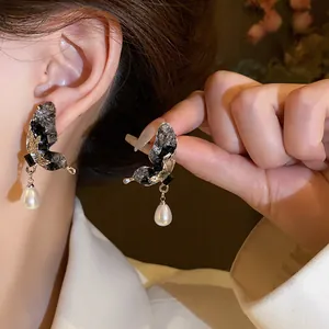 Elegante primo piano di orecchini a farfalla con cristalli e perle su perni in argento.