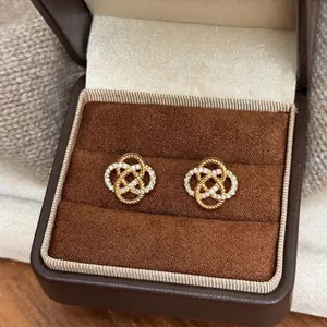 Detailed macro view of gold hollow flower earrings with sparkling zirconia in a box
