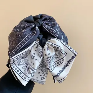 Close-up of vintage black and white paisley bow hair claw clip for women accessory