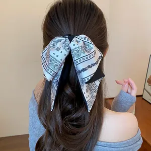 Close-up detail of a vintage paisley pattern bow hair clip styled in a half-up hairstyle