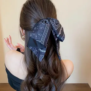 Back view of a model wearing a retro paisley bow hair clip in a half-up hairstyle.
