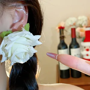 Primo piano di eleganti orecchini a lobo a fiore in tessuto bianco con perline