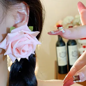 Primo piano dettagliato di un orecchino a rosa in tessuto rosa con perline a goccia