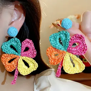 Vibrant handmade raffia woven flower earrings with colorful bohemian holiday style