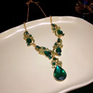 Luxury emerald green teardrop pendant necklace with gold plated chain and rhinestones.