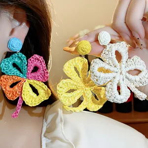 Detailed view of handmade Raffia grass woven flower earrings in multiple colors