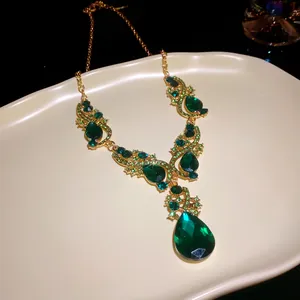 Close-up of luxury emerald teardrop pendant necklace with gold rhinestones details