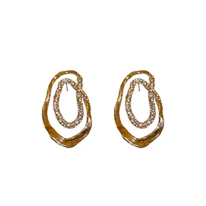 Elegantes pendientes ovalados irregulares chapados en oro con detalles de circonitas