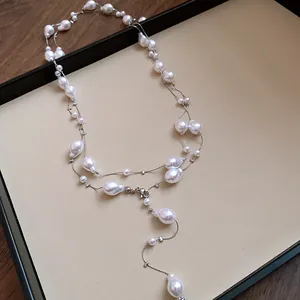 Detailed view of an elegant three-layer French necklace with irregular white pearls