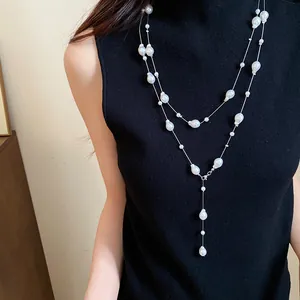 Detailed shot of an elegant layered irregular pearl necklace on a black turtleneck.