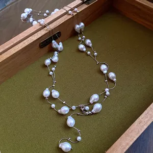 Elegant multi-layered necklace featuring irregular white pearls inside a vintage wooden box