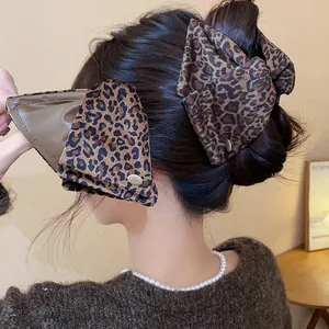 Close-up detail of a stylish brown leopard print shark clip shown on an Asian model's hair