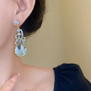 Close-up of elegant waterdrop crystal dangling earrings with blue rhinestone accents