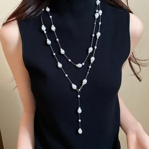 Elegant French layered necklace with irregular baroque pearls on a black turtleneck