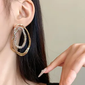 Elegantes pendientes de aro ovalados irregulares bañados en oro con cristales brillantes