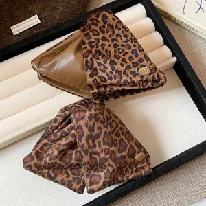 Detail view of large leopard print hair claw clips with gold logo on jewelry tray