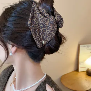 Large leopard print bow hair claw clip for thick hair shown in a styling detail
