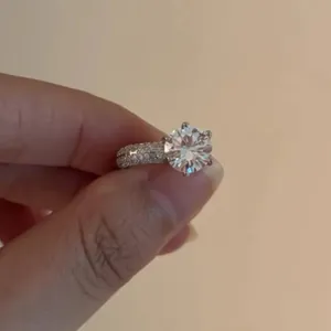 Elegant six-prong silver ring featuring a large round solitaire and paved zircons.