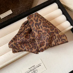 Detailed view of the leopard print triangle claw clip placed in a jewelry tray.