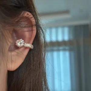 Detailed macro view showing a minimalist circular cubic zirconia ear cuff on a model's ear