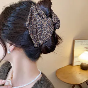 Detailed view of large leopard print acrylic hair claw clip holding a bun hairstyle