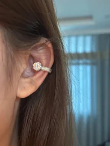 Close-up view of a minimalist round zircon ear cuff worn elegantly on the ear.