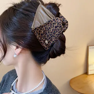 Close-up of a large leopard print shark hair clip featuring a chic triangle fabric design