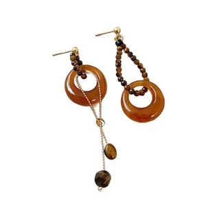Vintage Tigerauge Perlenohrringe asymmetrisch mit goldenen Akzenten weißer Hintergrund