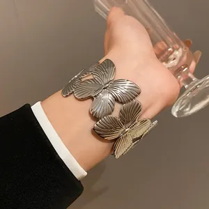 Detailed close-up view of a stylish silver butterfly-shaped cuff bracelet on a wrist