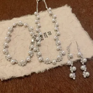 Vintage jewelry set featuring irregular pearls and rhinestones including necklace and bracelet