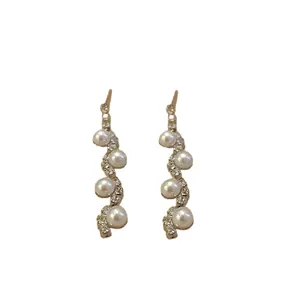 Elegant retro gold dangling earrings featuring irregular pearls and sparkling rhinestones design