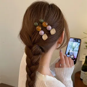 Detail of Korean style resin bead hair clips worn on braided hair in lifestyle setting