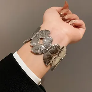 Detailed macro view of a silver butterfly cuff bracelet showing intricate wing patterns