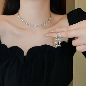 Elegant pearl and rhinestone necklace with matching earrings set worn by a model