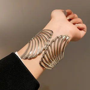 Detailed shot of an elegant silver metal leaf open cuff bracelet worn on a female wrist