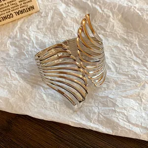 Detailed macro view of silver-tone leaf design open bangle with elegant hollow lines