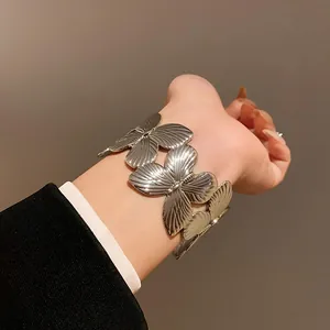 Close-up of vintage silver butterfly open cuff bracelet worn with a black suit