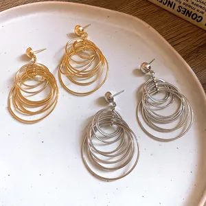 Detailed macro view showing the multi-layered concentric hoop earrings in gold and silver finishes