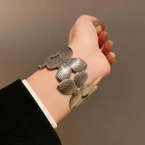 Vintage silver butterfly wide bracelet shown on wrist with elegant manicure