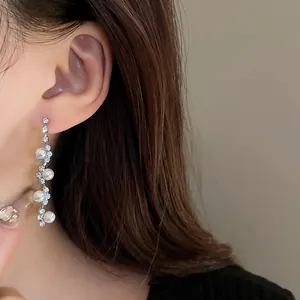 Close-up view of elegant silver drop earrings featuring pearls and sparkling rhinestones