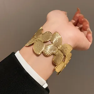 Elegant gold-tone wide open cuff bangle with detailed butterfly motifs for a luxury look